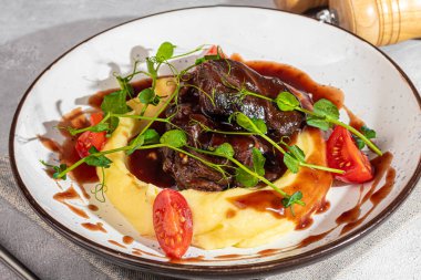 Domates ve mikroyeşilliklerle süslenmiş tatlı ve ekşi soslu patates püresi. Restoran yemeği. Boşluğu kopyala