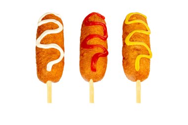 Farklı dolgulu ve farklı soslu mısırlı sosisler. Beyaz arka planda izole edilmiş. Boşluğu kopyala