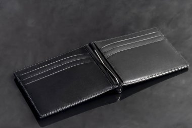 Para ve kart saklamak için siyah deri erkek cüzdanı. Karanlık bir arka planda. Boşluğu kopyala