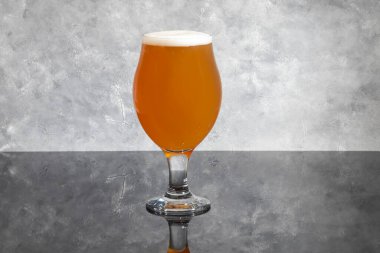 Siyah arka planda açık renkli ve koyu biralı bardaklar. Masada fındık ve kraker var. Bol köpüklü. Boşluğu kopyala