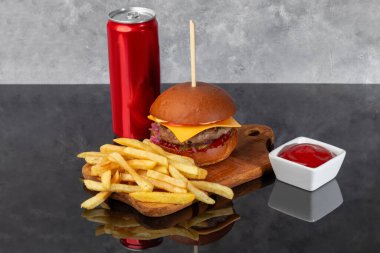 Tahta üzerinde hamburgerle köfte, domates, peynir, salatalık ve marul. Arka planda bir bardak bira. Boşluğu kopyala