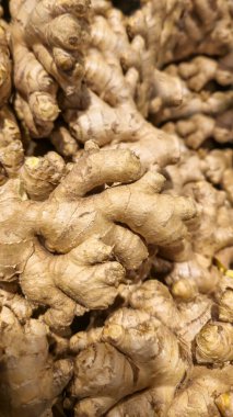 Mağazadaki tezgahın üzerinde satılık zencefil kökü. Sonbahar hasadı. Vitaminler