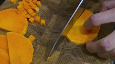 Çorba yapmak için balkabağını küp küp doğramak. Tahta bir tahtanın üzerinde. Ev yemeği. Boşlukları kopyala