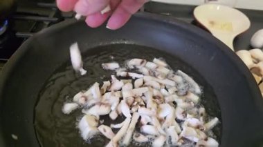 Kızartma tavasında mantarlar, yakınlarda bir kesim tahtası. Pastayı adım adım hazırlıyorum. Talimatlar.