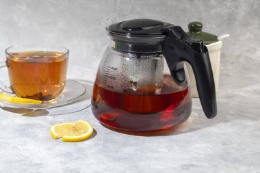 İçinde metal süzgeç olan cam çaydanlık. Mutfak aletleri gri arka planda. Boşluğu kopyala