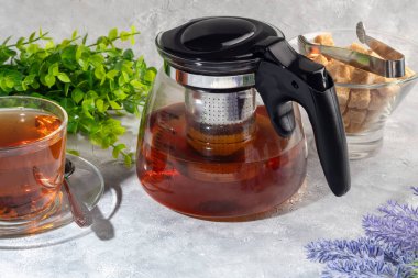 İçinde metal süzgeç olan cam çaydanlık. Mutfak aletleri gri arka planda. Boşluğu kopyala