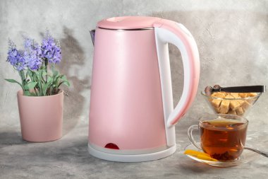 İçinde metal süzgeç olan çaydanlık. Mutfak aletleri gri arka planda. Boşluğu kopyala