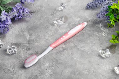 Gri arka planda plastik ambalajlı diş fırçaları. Satılık. Boşluğu kopyala