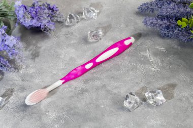 Gri arka planda plastik ambalajlı diş fırçaları. Satılık. Boşluğu kopyala