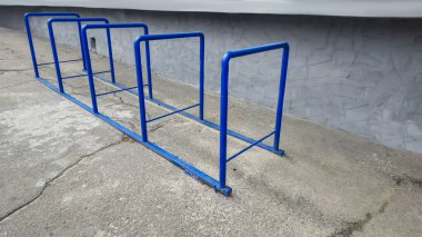 Süpermarketin yanındaki metal bisiklet parkı. Mavi borulardan yapılmış park yeri. Boşluğu kopyala