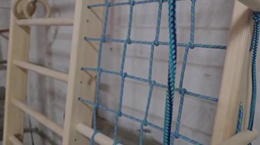 Merdivenli çocuklar için spor duvarı. Elle yapılmış ahşap ve iplerden. Üretim için atölye