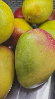 Süpermarkette tezgahın üzerinde mango meyveleri var. Satılık. Sağlıklı yiyecekler. Ürün görüntüsü