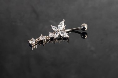 Göbek delikli küpeler ve kenevir yaprağı şeklinde bir kolye. Yaz dekorasyonu. Piercing