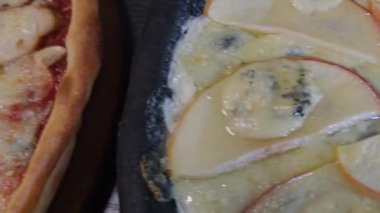 Mürekkep balığı mürekkebi armut peyniriyle ballı siyah hamurdan pizza. Siyah bir arka planda. Restoranlar için menü