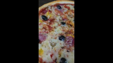 Mürekkep balığı mürekkebi armut peyniriyle ballı siyah hamurdan pizza. Siyah bir arka planda. Restoranlar için menü