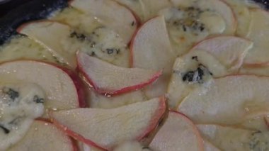 Mürekkep balığı mürekkebi armut peyniriyle ballı siyah hamurdan pizza. Siyah bir arka planda. Restoranlar için menü