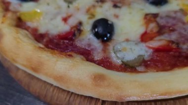 Mürekkep balığı mürekkebi armut peyniriyle ballı siyah hamurdan pizza. Siyah bir arka planda. Restoranlar için menü