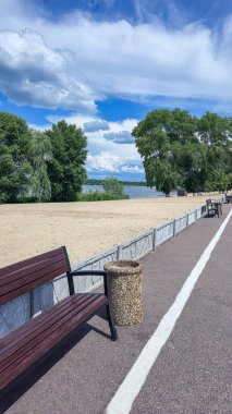 Ahşap banklar ve çöp kutuları yolun kenarında park dinlenme alanında. Yaz