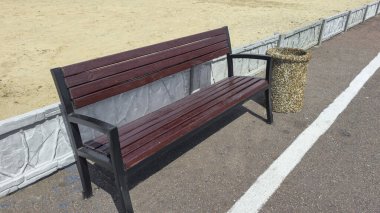 Ahşap banklar ve çöp kutuları yolun kenarında park dinlenme alanında. Yaz