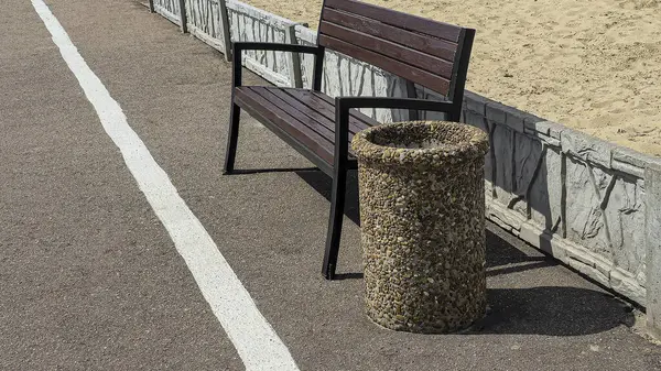 Ahşap banklar ve çöp kutuları yolun kenarında park dinlenme alanında. Yaz