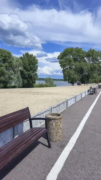 Ahşap banklar ve çöp kutuları yolun kenarında park dinlenme alanında. Yaz