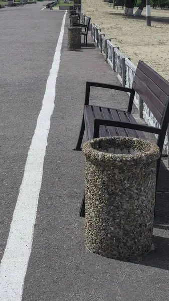 Ahşap banklar ve çöp kutuları yolun kenarında park dinlenme alanında. Yaz