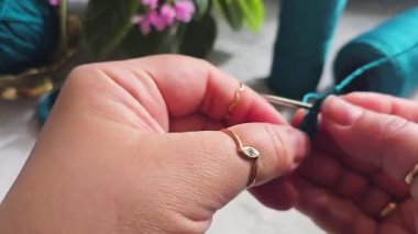 Örgü kancasıyla yeşil ipliklerden bir ürün örmek. Adım adım bir bilezik örmek için talimatlar. El yapımı mücevherler.