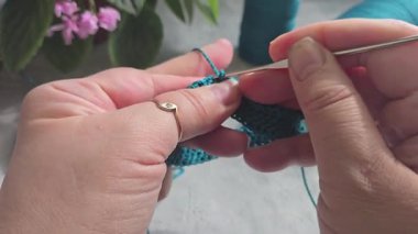 Örgü kancasıyla yeşil ipliklerden bir ürün örmek. Adım adım bir bilezik örmek için talimatlar. El yapımı mücevherler.