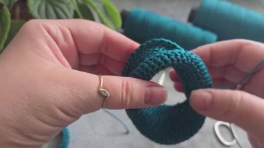 Örgü kancasıyla yeşil ipliklerden bir ürün örmek. Adım adım bir bilezik örmek için talimatlar. El yapımı mücevherler.