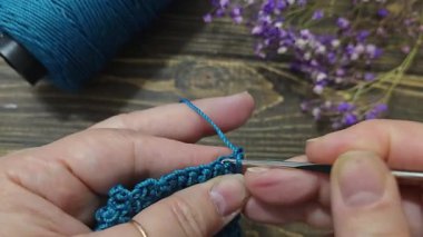Örgü kancasıyla yeşil ipliklerden bir ürün örmek. Adım adım bir bilezik örmek için talimatlar. El yapımı mücevherler.
