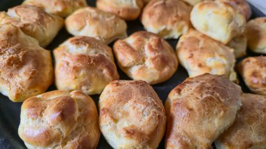 Karamelli hafif bir tabakta Croquembouche. Ev yapımı kremalı ekkler. Ev yapımı hamur işleri