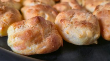 Karamelli hafif bir tabakta Croquembouche. Ev yapımı kremalı ekkler. Ev yapımı hamur işleri