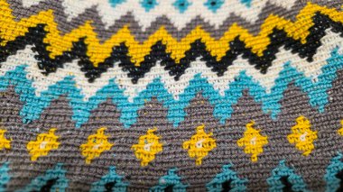 Tığ işi desenli çok renkli iplikler. Sarı, gri, siyah ve diğer renkler jakardoda örülmüş kumaş. El yapımı.