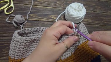 Çantanın altı mavi örgü iplikten örülmüş. Ahşap bir arka planda. El yapımı..