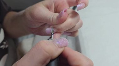 Usta tırnak uzatma yapıyor. Manikür. Çivi düzeltme. Eller ön planda. Salon servisi