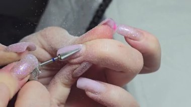 Usta tırnak uzatma yapıyor. Manikür. Çivi düzeltme. Eller ön planda. Salon servisi
