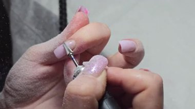 Usta tırnak uzatma yapıyor. Manikür. Çivi düzeltme. Eller ön planda. Salon servisi