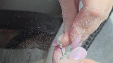 Usta tırnak uzatma yapıyor. Manikür. Çivi düzeltme. Eller ön planda. Salon servisi