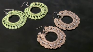 İnce pamuk ipliklerden yapılmış, elle örülmüş yuvarlak yeşil küpeler. El yapımı. Kadınlar için mücevherler. Kostüm mücevherleri