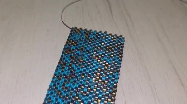 Turkuaz bilezik, altın kaplama boncuklar ve hafif arka plan. El yapımı. Evde dekorasyon ve mücevher. Boncuklardan dokuma.