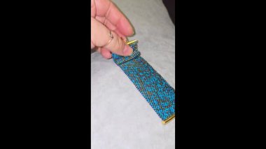 Turkuaz bilezik, altın kaplama boncuklar ve hafif arka plan. El yapımı. Evde dekorasyon ve mücevher. Boncuklardan dokuma.