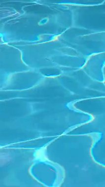 Havuzdaki su mavi, parıltılı ve güneşte parlıyor. Sağlıklı bir yaşam tarzı. Çocuklar için eğlence.