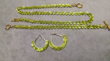 Hafif arka planda tohum boncukları ve cam boncuklardan yapılmış el yapımı yuvarlak küpeler. Ürün gösterisi. Moda trendleri. Boşluğu kopyala.