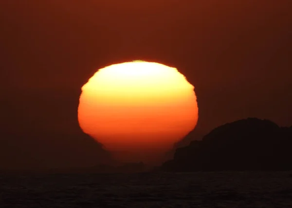 stock image Deep red sun going down behind the horizon