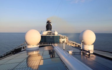 Sabah güneşinde yelken açan bir gemi.