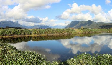Huzurlu gölette yansıyan bulutlar