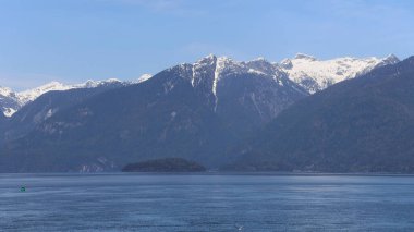 Rüzgarlı gölün üzerindeki karlı dağlar