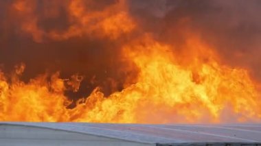 Large flames rising from a large building fire. Slow motion footage of a massive fire. High quality FullHD footage. Slow motion.