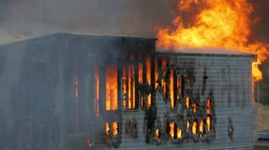 Trailer home on fire. Slow motion. Large house fire ablaze with large flames and smoke. High quality FullHD footage. Slow motion.