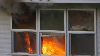 Fire and smoke rising out of windows while glass shatters and falls to the ground. Slow motion footage of a building fire. High quality FullHD footage. Slow motion.